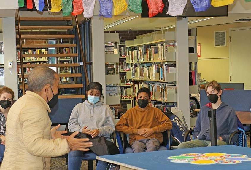 Lama Tenzin visits with students in library